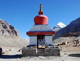 07 Kangnyi Chorten With Mount Kailash Behind On Mount Kailash Outer Kora Just to the west of Tarboche is Kangnyi Chorten (08:38), meaning two-legged chorten, with Mount Kailash behind and Tarboche to the right. It is auspicious act for a pilgrim to walk through the small chorten archway.